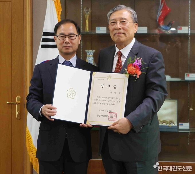 박영수 사무총장(왼쪽)이 최영열 원장에게 당선증을 전달하고 기념사진을 촬영하고 있다.