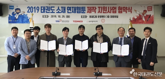 우에서 3번째 재단 이기동 진흥사업부장, 우에서 4번째 토리컴즈 주식회사 송순규 대표, 좌에서 4번째 (주)투믹스 문영돈 편집장, 좌에서 5번째 (주)유주얼 미디어 민성욱 부대표