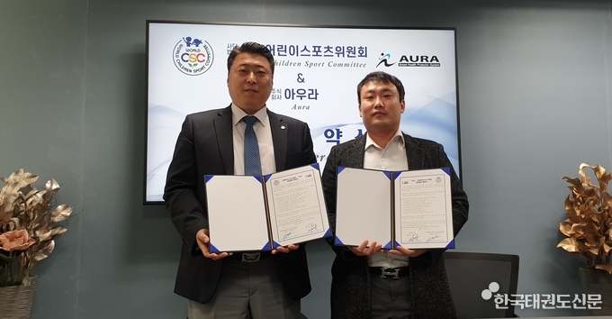 체결식 사진(좌측-세계어린이스포츠위원회 서현석 위원장, 우측-아우라 성제혁 대표이사)