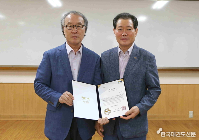 전갑길 국기원 이사장(오른쪽)이 손천택 정관개정소위원회 위원장에게 위촉장을 전달한 뒤 기념촬영을 하고 있다.