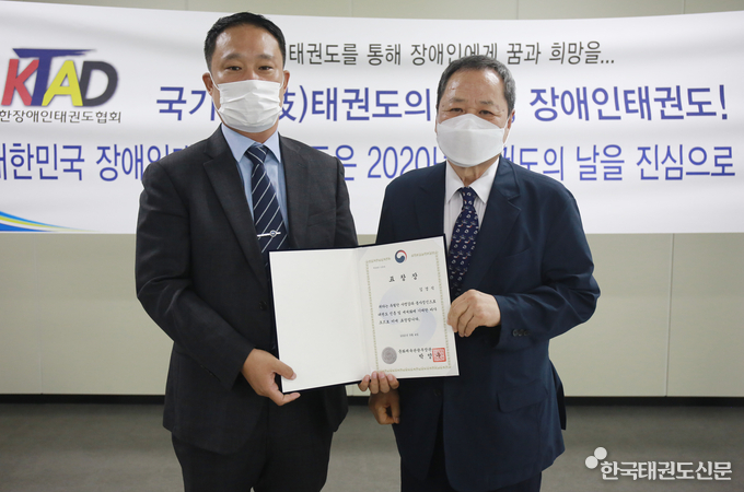 대한장애인태권도협회 장용갑 회장(우)이 2020 태권도의 날을 맞아 장애인태권도 활성화 공로자로 선정된 김경식 국가대표 지도자(좌)에게 문화체육관광부 장관 표창을 수여하고 있다.