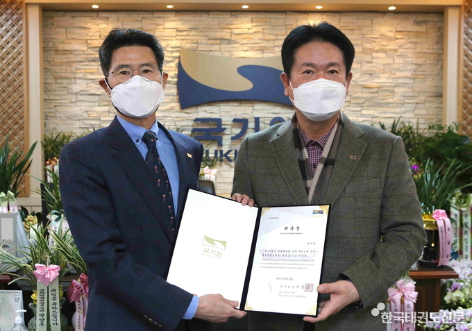 국기원 홍보특별보좌관(대변인)으로 위촉된 송하칠 전 매일경제 부국장(왼쪽)에게 이동섭 국기원장이 위촉장을 수여하고 기념촬영을 하고 있다.