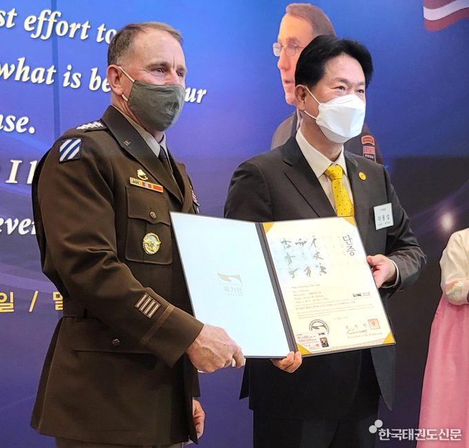 5월 13일(목) 오전 8시 ‘로버트 에이브람스 한미연합사령관 환송 행사’에서 이동섭 국기원장(오른쪽)이 로버트 B. 에이브람스 한미연합사령관에게 명예 6단증을 수여하는 모습.