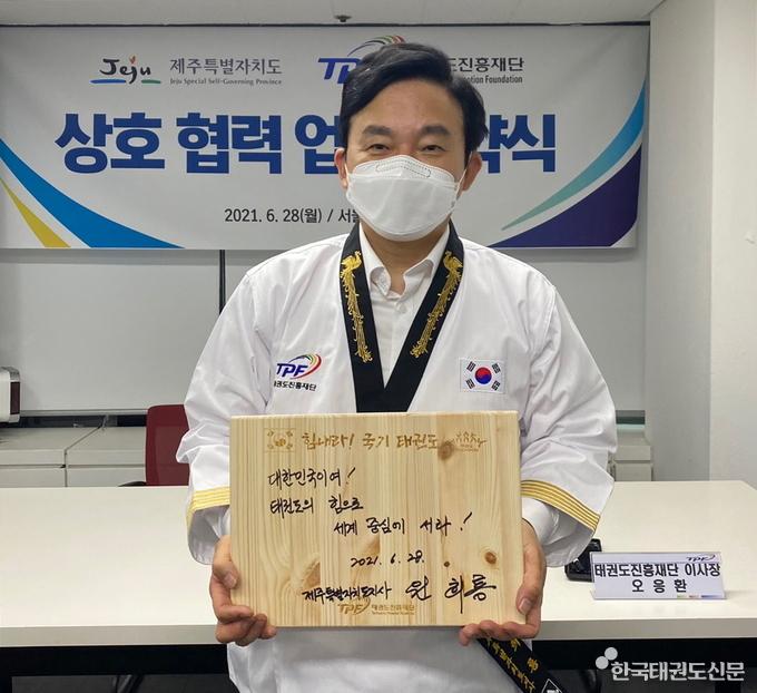 원희룡 지사가 기념 송판에 국기 태권도를 응원하는 메시지를 작성 후 촬영하고 있다.