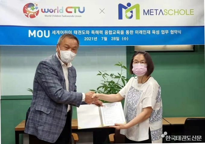 좌, 세계어린이태권도연맹 박수남 총재와 메타스콜레 정해영 대표 업무 협약서를 교환하며 기념 사진을 찍고 있다.