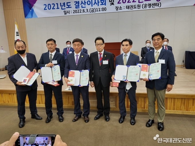 김경덕 회장으로부터 신규 회원증을 받고 있는 회원들의 모습