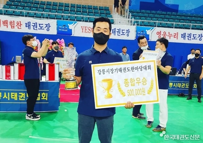 종합우승을 차지한 김영운 관장이 우승 트로피를 들고 기념 촬영을 하고 있다.