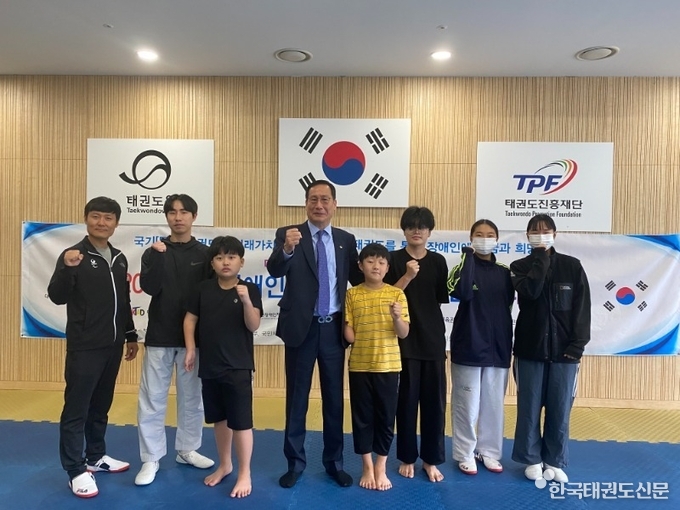 대한장애인태권도협회 오응환 관리위원장이 훈련장에 방문하여 선수들과 단체사진을 찍는 모습