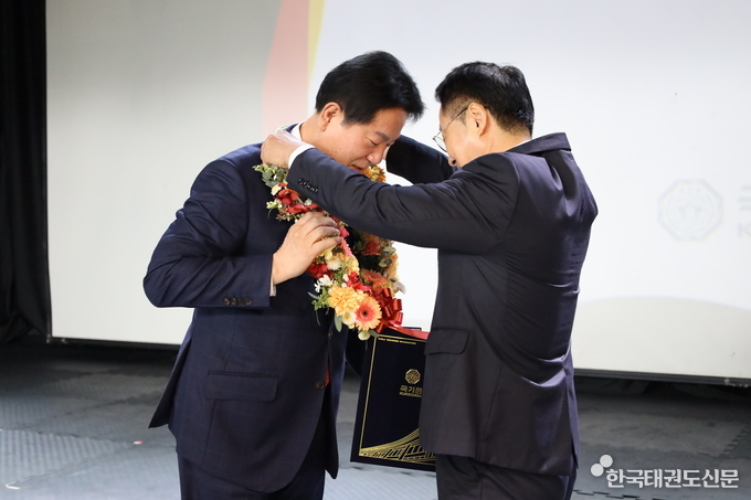 이동섭 국기원장이 김목운 국기원선거관리위원장으로부터 꽃다발을 증정 받는 모습