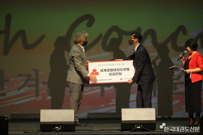 세계경찰태권도연맹 방승호 총재(왼쪽)가 사랑의 열매에 성금을 전달하고 있다.