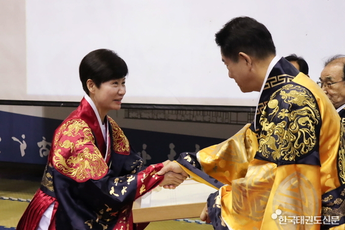 임난희 사범이 이동섭 국기원장으로부터 9단증을 수여받고 있다.