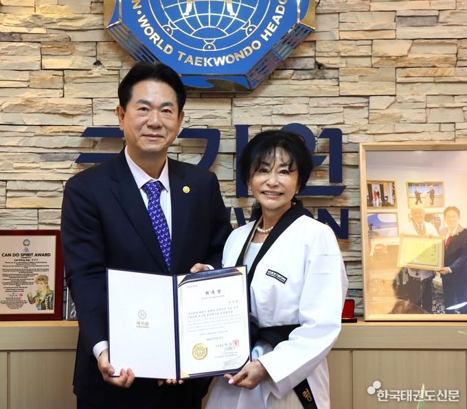 이동섭 국기원장(왼쪽)이 가수 진미령(오른쪽) 씨에게 홍보대사 위촉장을 수여하며 기념촬영을 하고 있다.